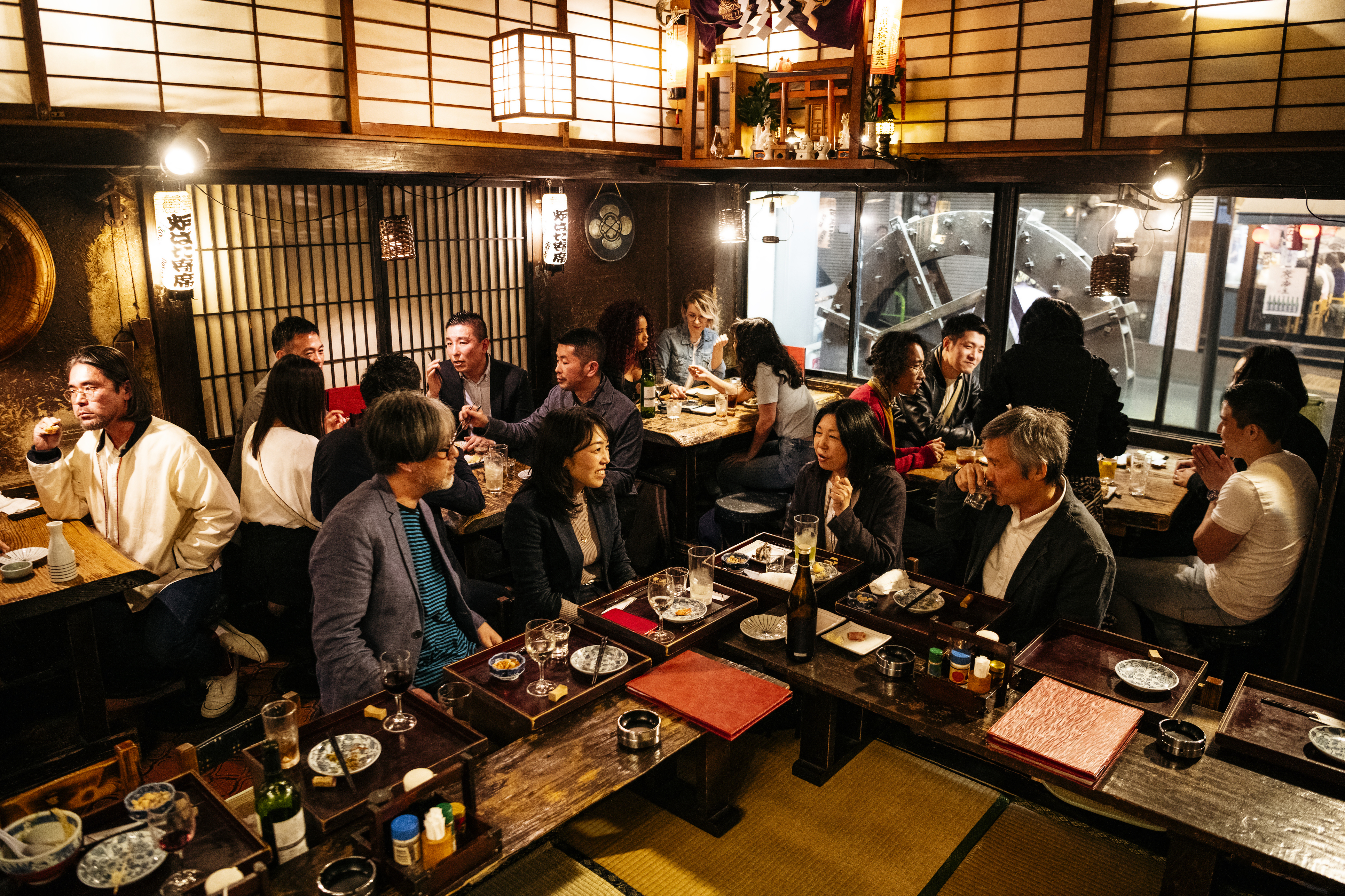 Co-workers relaxing in Japanese restaurant with food and drink
